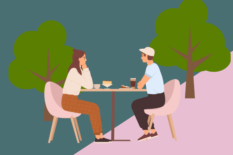 Man and woman enjoying lunch at a table in the park