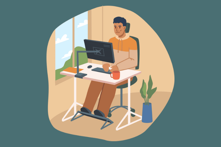 Man sitting at his work from home desk with a foot stool and ergonomic seat